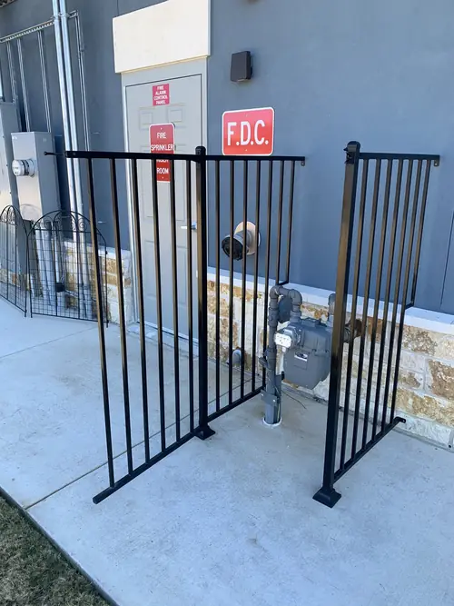 Steel protective railing installed around a commercial fire riser and meter