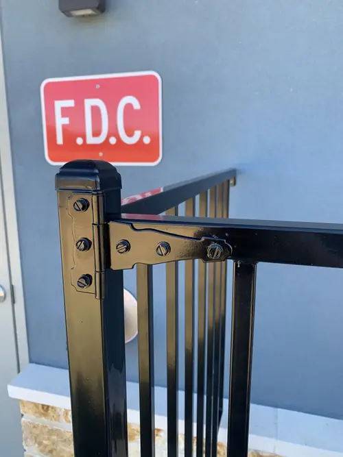 Detail of a welded strap hinge on the black steel guard rail
