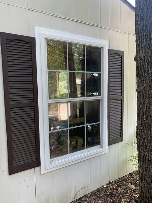 Replacement window installed with fresh trim and shutters