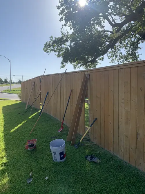 Privacy fence under construction with tools staged along the line