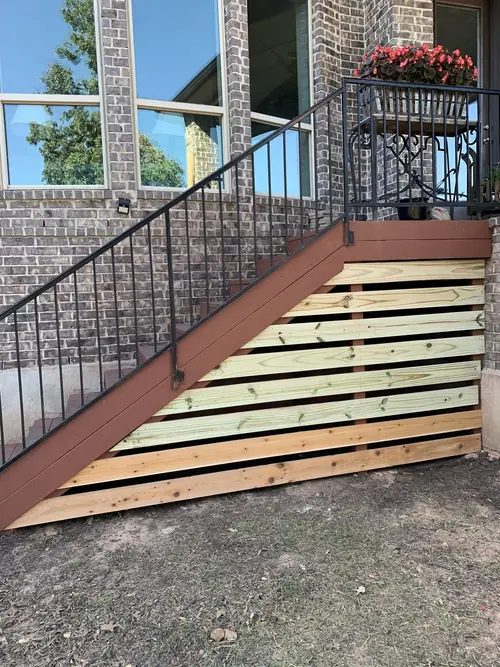 Horizontal cedar slat screen built in beneath an exterior staircase